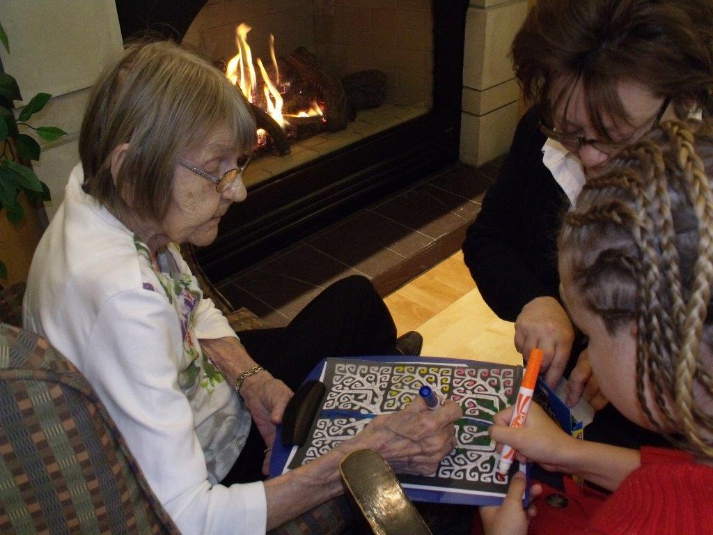 Valla and granddaughter colouring by the fire